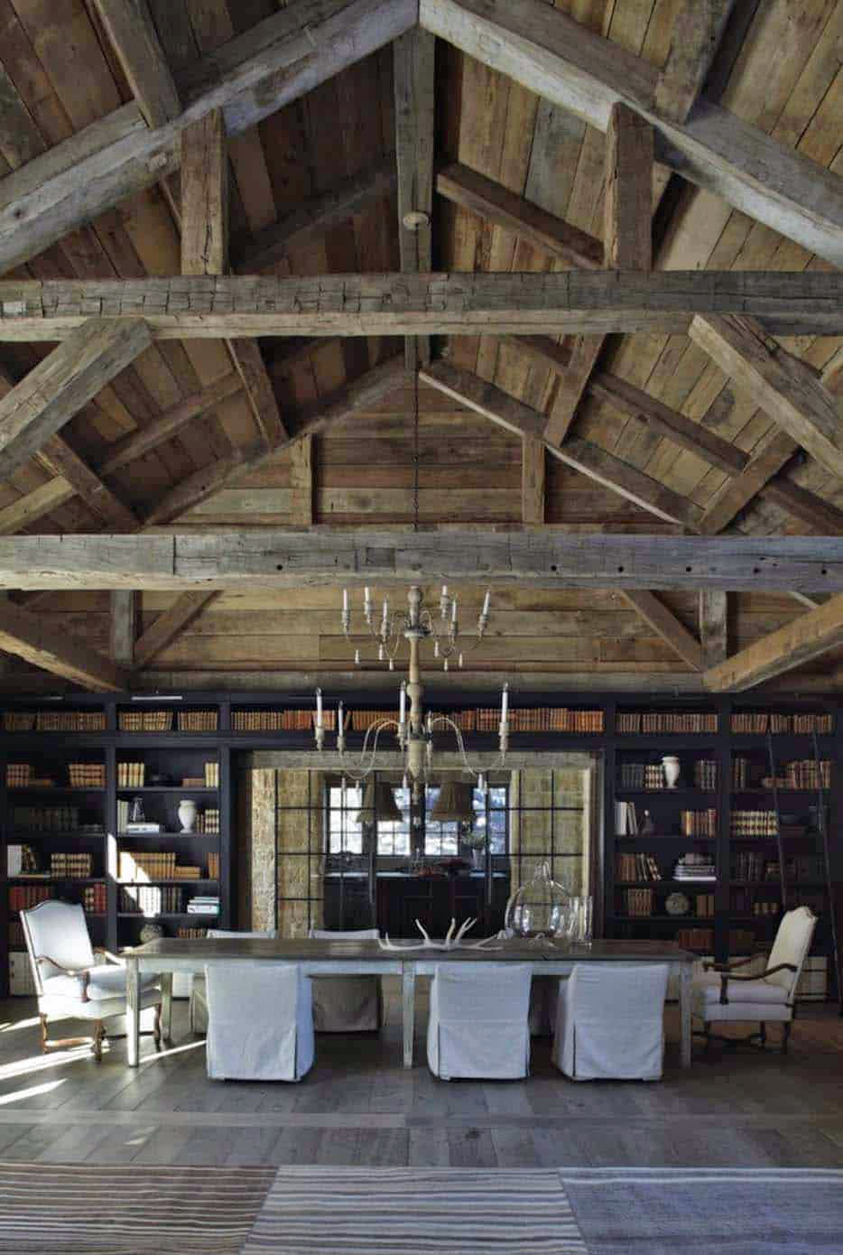A dining table in a large scale barn style house.